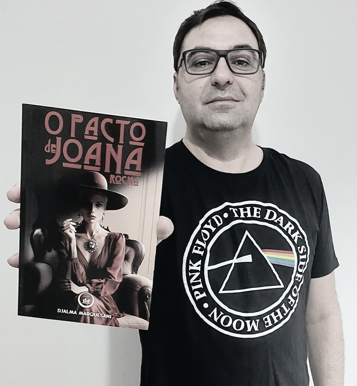 Imagem do autor Djalma Marquesani segurando seu livro O pacto de Joana Rocha