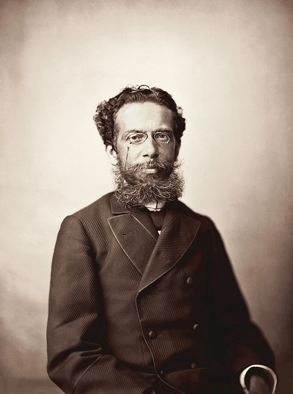 Retrato do escritor Machado de Assis, capturado em 1890 pelo fotógrafo Marc Ferrez, revela uma figura de postura serena e olhar introspectivo. A composição sóbria e a iluminação suave destacam a profundidade psicológica do maior nome da literatura brasileira. Created with GIMP