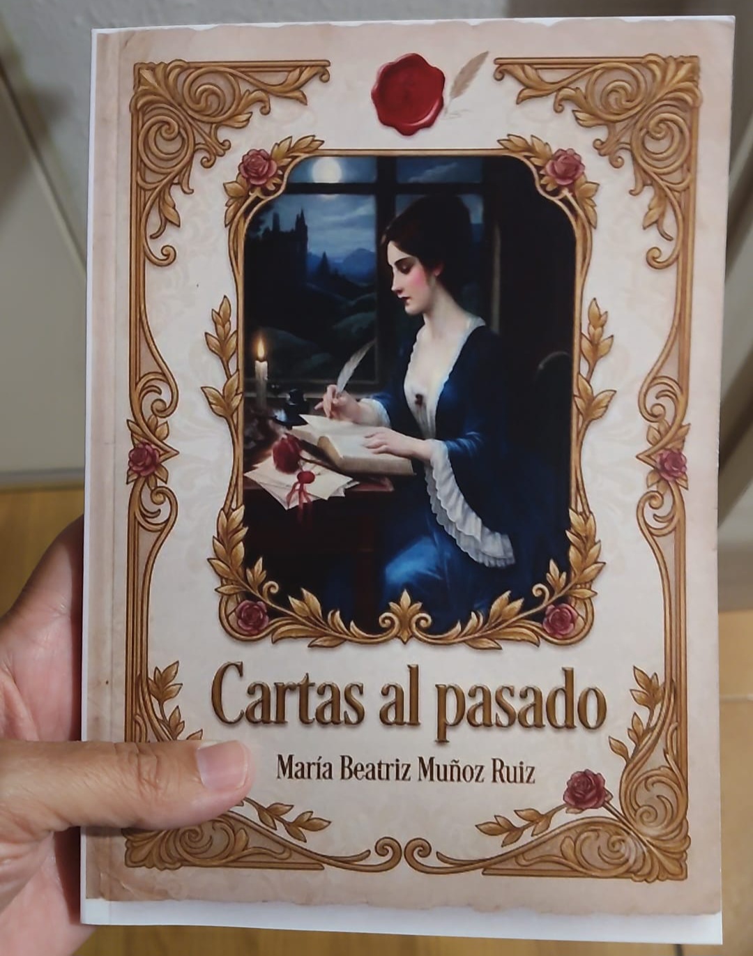 Capa do livro "Cartas al pasado", de María Beatriz Muñoz Ruiz. A ilustração central mostra uma mulher escrevendo uma carta à luz de uma vela perto de uma janela com lua cheia. A capa possui molduras ornamentadas em estilo clássico com detalhes de rosas e um selo de cera vermelha.